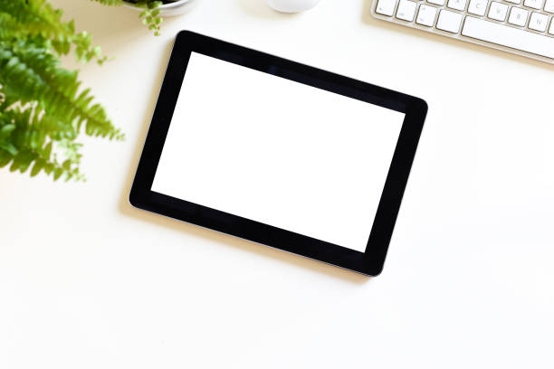 Photo of Blank white screen on portable tablet device on modern office desk