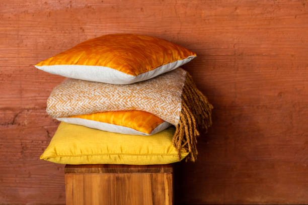 istock Pillows on chair against orange wall. 1182073057