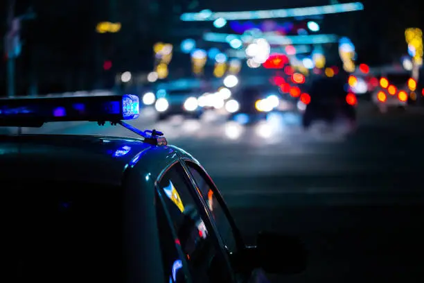 Photo of police car lights at night in city with selective focus and boke blur
