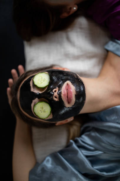 home spa treatment - facial mask spa treatment cucumber human face imagens e fotografias de stock