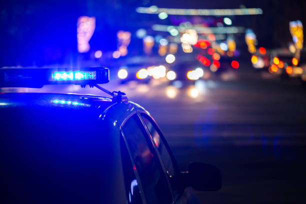 police car lights at night in city with selective focus and bokeh - crime scene investigation imagens e fotografias de stock