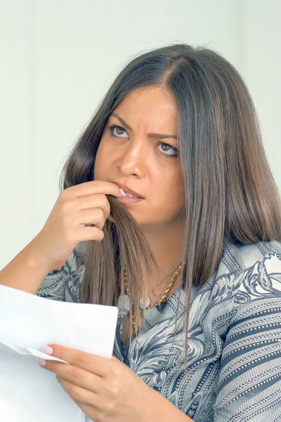 istock Business woman reading a document in office workspace. 1182076803