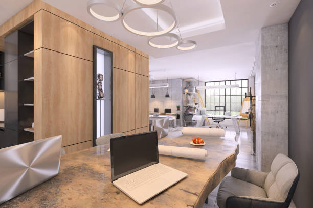 istock Modern office interior with large conference desk and open laptop with blank screen 1182076915