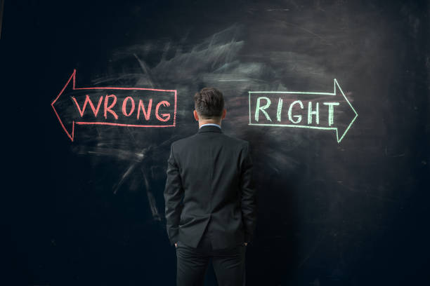 right vs wrong direction Businessman  having to take a decision. He is looking at a blackboard wall with the words wrong and right hand written on it oops stock pictures, royalty-free photos & images