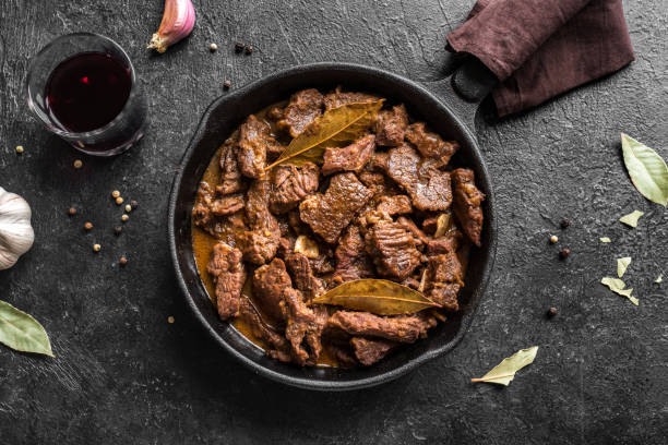 Beef Meat Stew Meat Stew. Beef stewed in red wine sauce, top view, copy space. Roasted beef meat. Braised beef portion meat. Slow cooked meat in cast iron pan. stew photos stock pictures, royalty-free photos & images