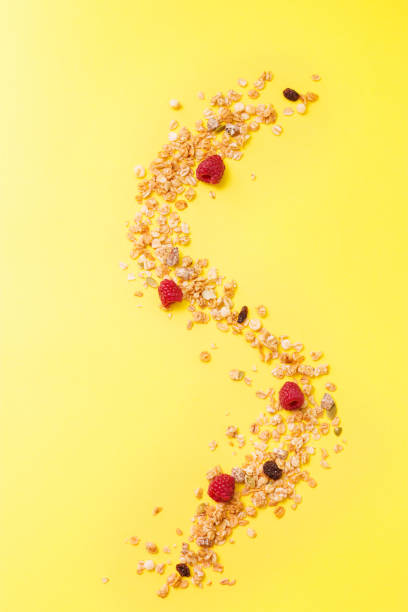 istock Crispy muesli with raspberry dry Breakfast isolated on yellow background selective focus, top view 1182078270