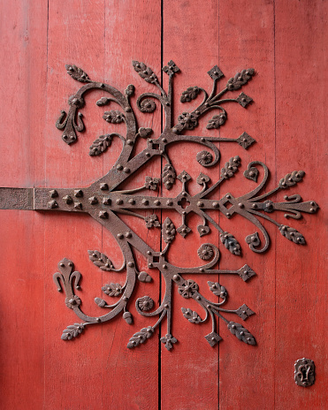 Detail of a wooden door with wheel and wrought iron