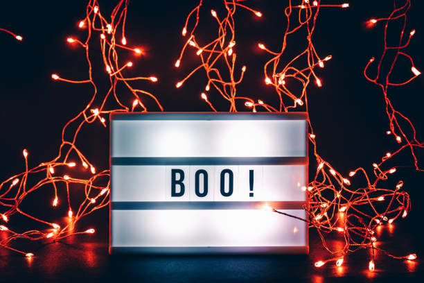 Halloween themed cinema light box on the dark toned background with lights garlands