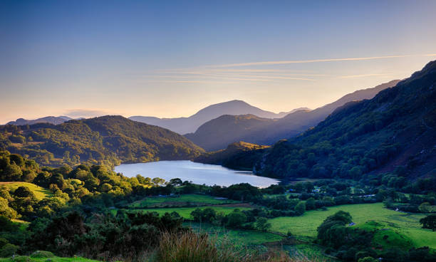 スノードニアの山々の後ろに沈む太陽として、リン・グウィナント(湖) - wales ストックフォトと画像