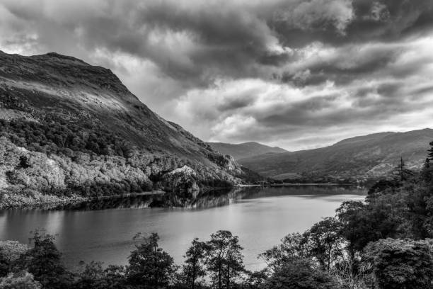 first sun on shinning gallt y wenallt next to llyn gwynant after a strom in snowdonia - nant gwynant imagens e fotografias de stock