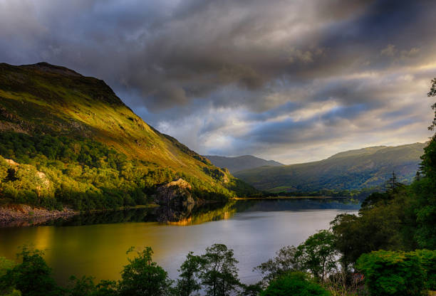 first sun on shinning gallt y wenallt next to llyn gwynant after a strom in snowdonia - nant gwynant imagens e fotografias de stock