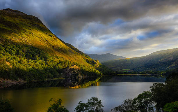 first sun on shinning gallt y wenallt next to llyn gwynant after a strom in snowdonia - nant gwynant imagens e fotografias de stock