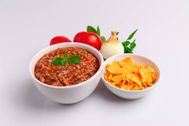 istock Bolognese (also know as Bolognesa or Bolonhesa) sauce and corn chips nachos in a white bowl isolated in white background, soft light, studio photo, copy space 1182094785