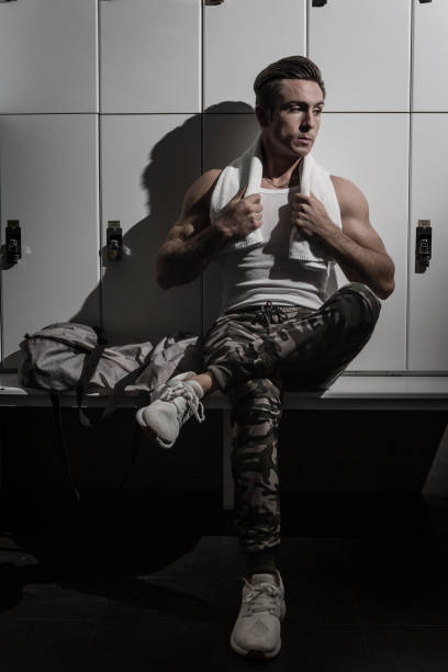 istock Relaxed athlete sitting near lockers 1182095409