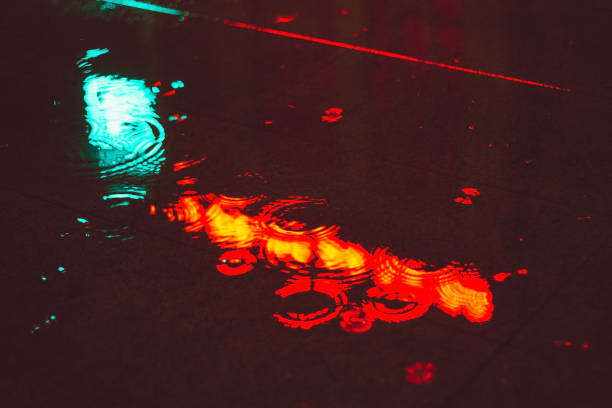 istock reflection of headlights on wet asphalt night abstract background 1182095450