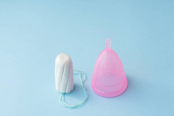 istock Period products tampon and menstrual cup on blue background, copy space 1182096011