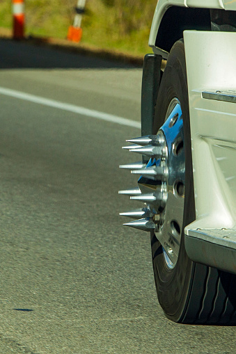 A semi cab sports front chrome wheels with long spike lug nuts