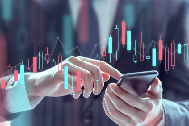 istock Businessman using a mobile phone to check stock market data, Technical price graph and indicator, Double exposure. 1182101614