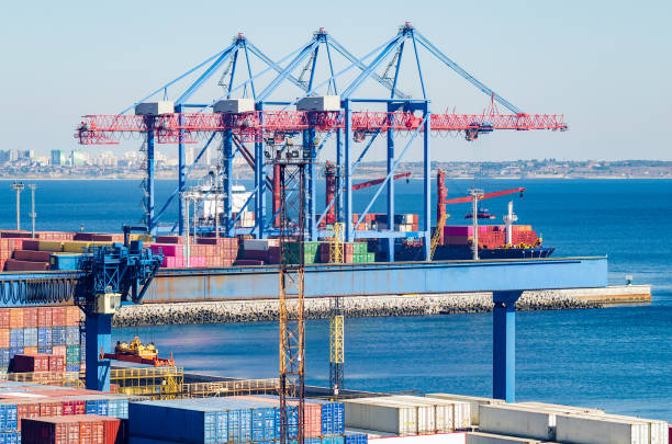 istock Port cargo crane loads a container onto a cargo ship 1182111536