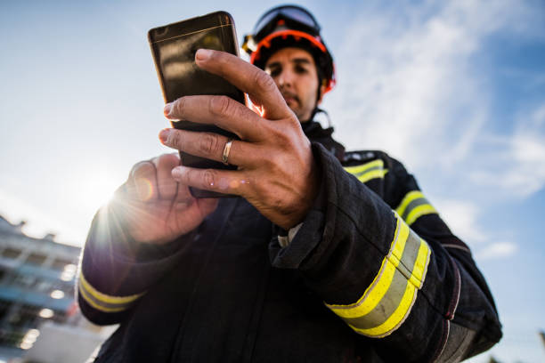 Firefighters in a rescue operation training, Man using a Smart Phone stock photo