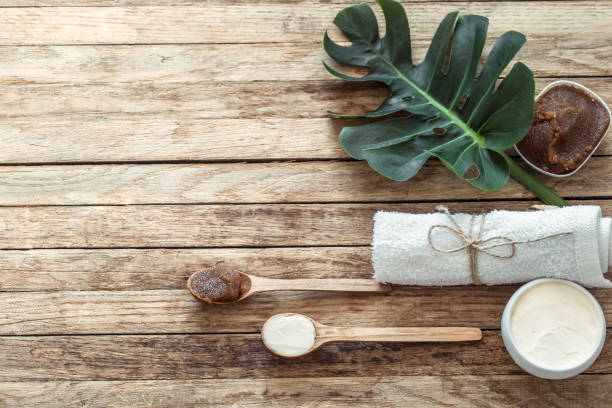 Spa composition with towels and tropical leaf on a wooden background.