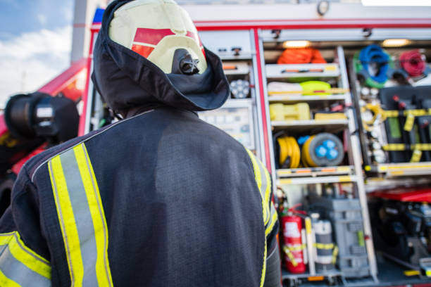 istock Firefighter back view standing by the Fire truck 1182116055