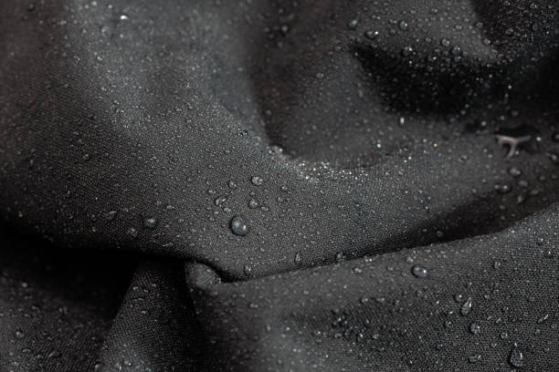 istock dark gray waterproof hydrophobic cloth closeup with rain drops selective focus background 1182127043