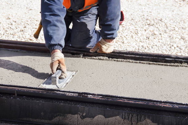 istock Hand of worker use trowel plastering a newly poured concrete on construction site. Leveling concrete with trowels 1182127178