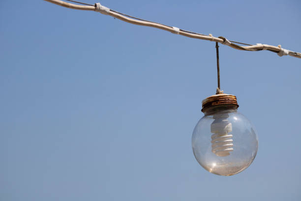 istock Transparent sphere and light bulb with savings inside. Hanging with cable. 1182128620