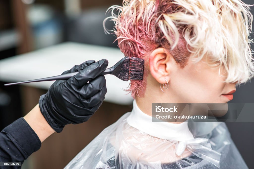 Friseur Hand in schwarzen Handschuhen malt die Haare der Frau in einer rosa Farbe. - Lizenzfrei Friseursalon Stock-Foto