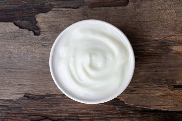 istock Yogurt white put in a glass put on a wooden background from top view. 1182140113