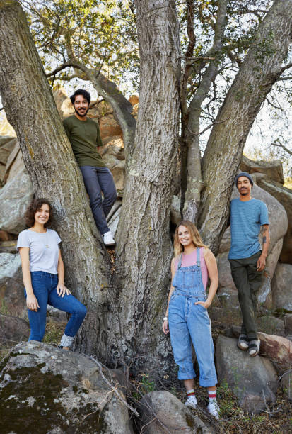 istock Smiling friends standing around a tree in the forest 1182141840
