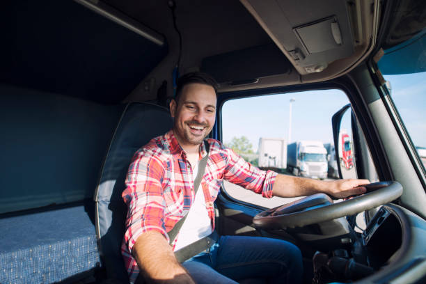 motorista de caminhão dirigindo seu caminhão e mudando de estação de rádio para tocar sua música favorita. camionista apreciando seu trabalho. serviços de transporte. - freight transportation audio - fotografias e filmes do acervo