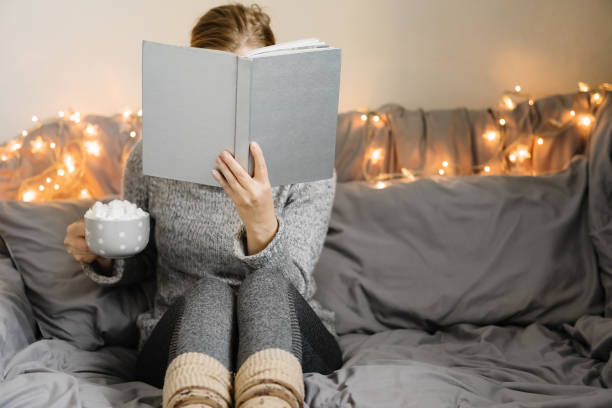istock Woman reading book in cozy room. 1182142905