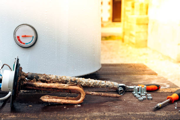 istock the heating element is covered with rust and scale, with screws on the background of the boiler, lying on a wooden table 1182143151