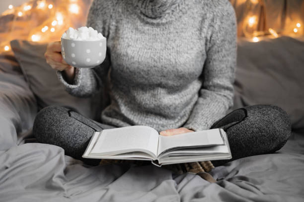 istock Woman reading book in cozy room. 1182143267