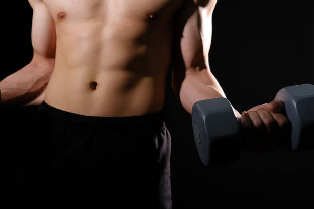 istock athletic muscular bodybuilder man with naked torso six pack abs working out with dumbbell. fitness  exercise concept 1182143299
