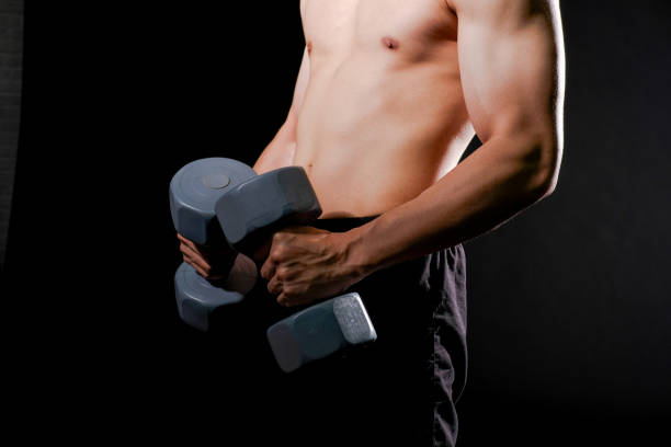 istock athletic muscular bodybuilder man with naked torso six pack abs working out with dumbbell. fitness  exercise concept 1182143306