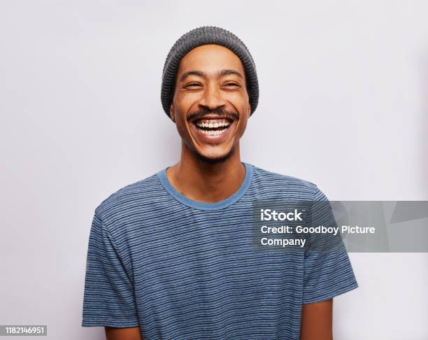Lachender Junger Mann Steht Vor Grauem Hintergrund Stockfoto und mehr Bilder von Männer - Männer, Porträt, Freisteller – Neutraler Hintergrund