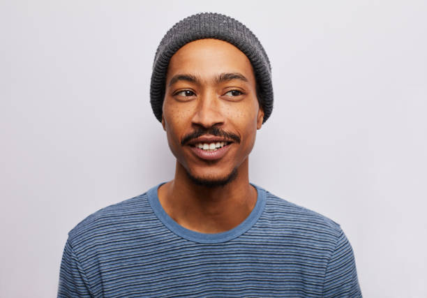 istock Smiling young man glancing sideways against a gray background 1182147068