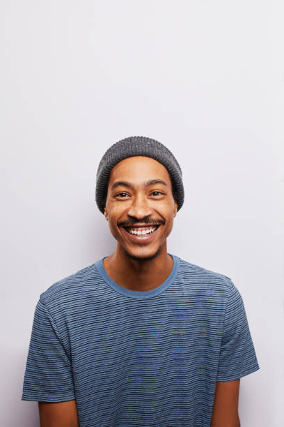 istock Stylish young man smiling while standing against a gray background 1182147886