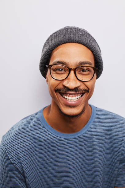istock Smiling young man wearing glasses standing against a gray background 1182147954