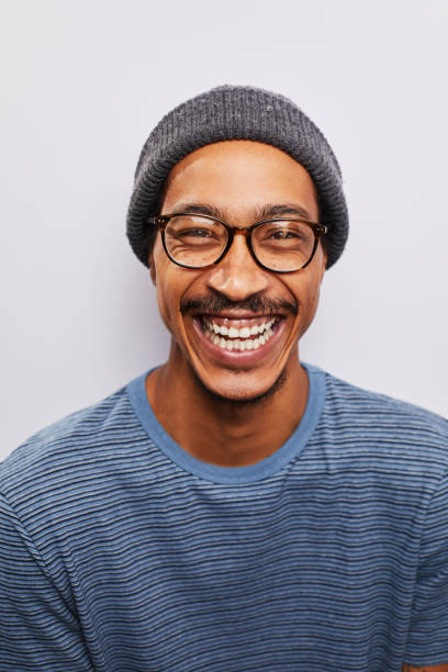 istock Laughing young man wearing glasses standing against a gray background 1182148009