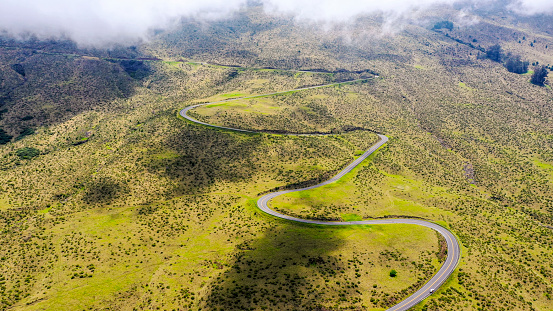 Long winding road after a scenic viewing stop on their sunrise bike trek down Haleakala, a nearly 10,000-foot volcano on Maui. Haleakala National Park.