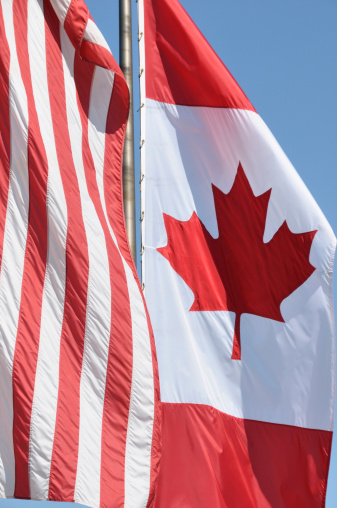 The Canadian flag waves in the breeze on a sunny day