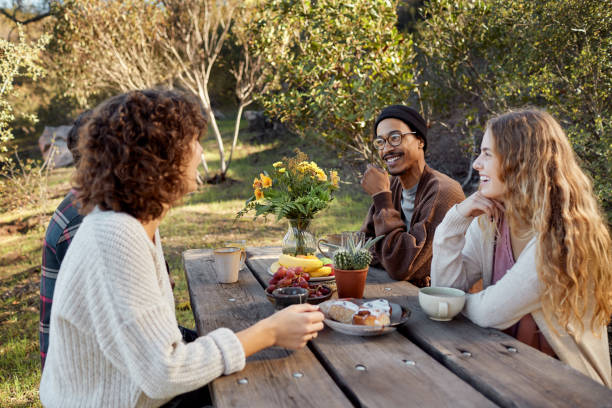 istock Smiling young friends having breakfast at a picnic table 1182152963