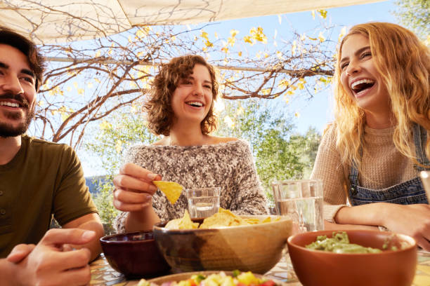 istock Young friends laughing while eating outside on a patio 1182159258