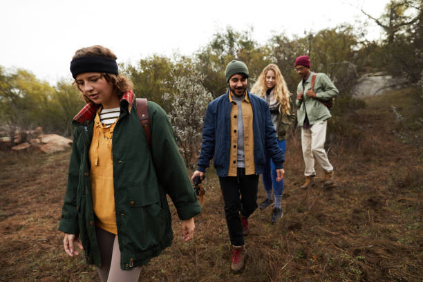 istock Young friends hiking together down a nature trail 1182169392