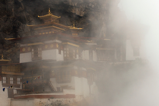 Paro, Bhutan - April 25, 2008: Close views through thick clouds of the mythical temple perched on the rocky cliff where Guru Rinpoche flew here on a tigress to subdue demons of Paro Valley and create a temple for the Bhutanese people to worship Buddha.