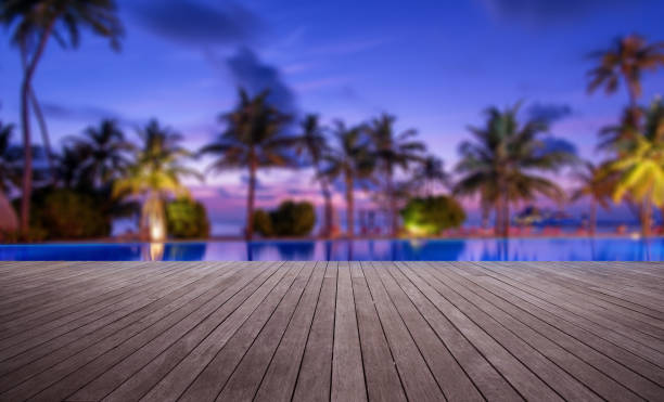 Wooden terrace beside tropical beach swimming pool at dusk Wooden terrace beside tropical beach swimming pool at dusk holiday camp stock pictures, royalty-free photos & images